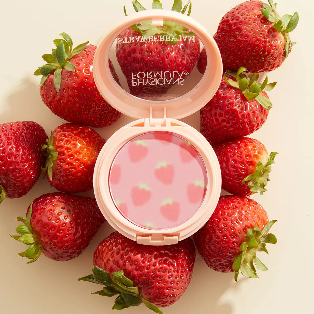 Physicians Formula Strawberry Jam blush compact surrounded by fresh strawberries