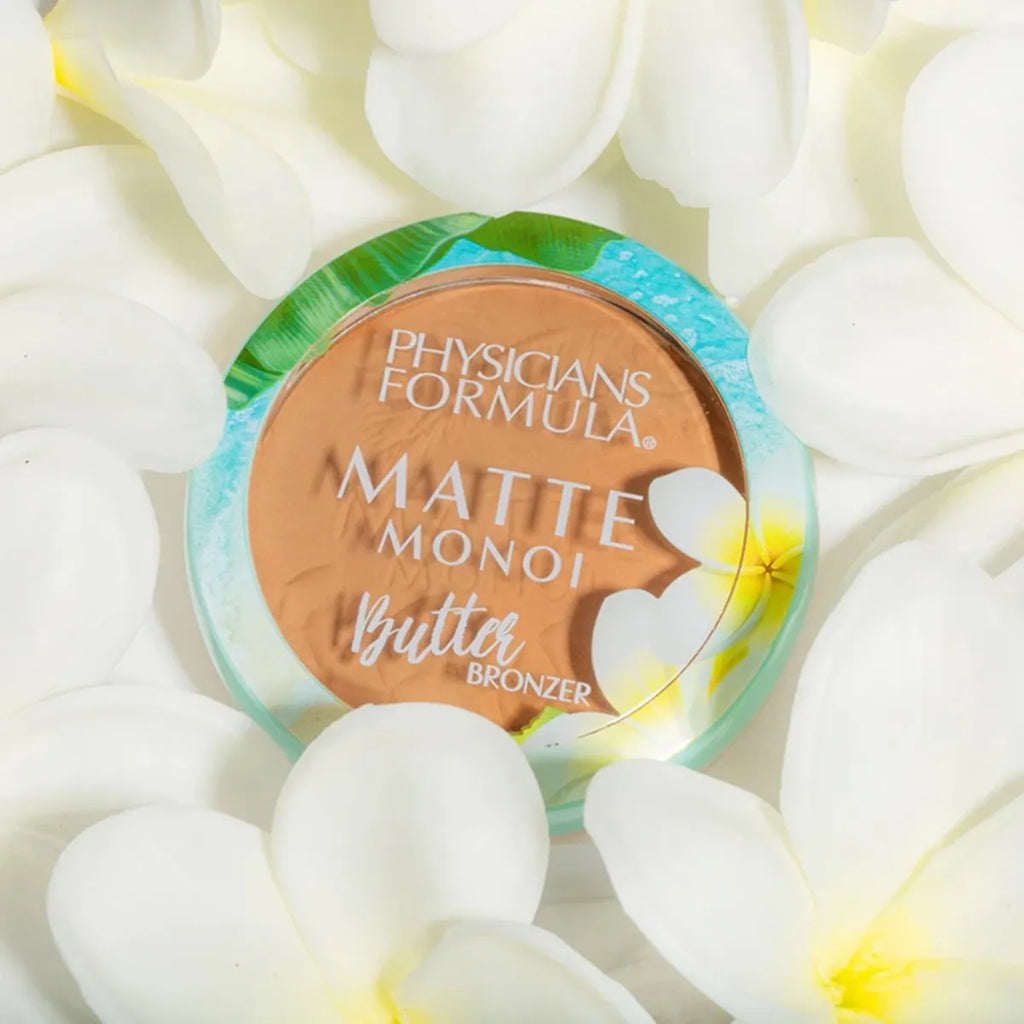 Physicians Formula Matte Monoi Butter Bronzer compact surrounded by white tropical flowers