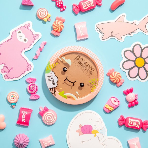 Butter Puff Bronzer Hero Image, on light blue background with various candies and stickers surrounding the product